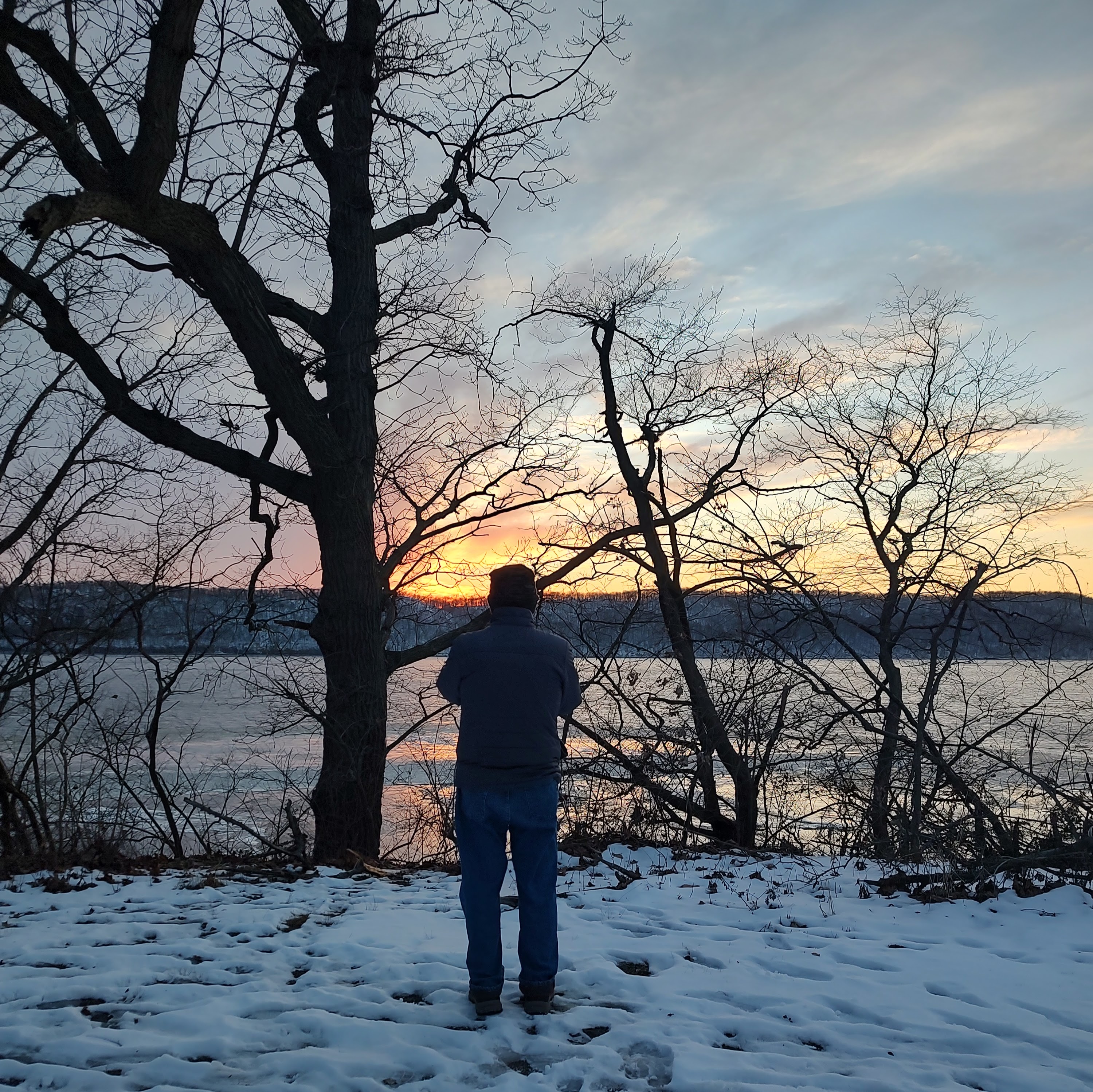 Silhouette watching a winter sunset over a lake